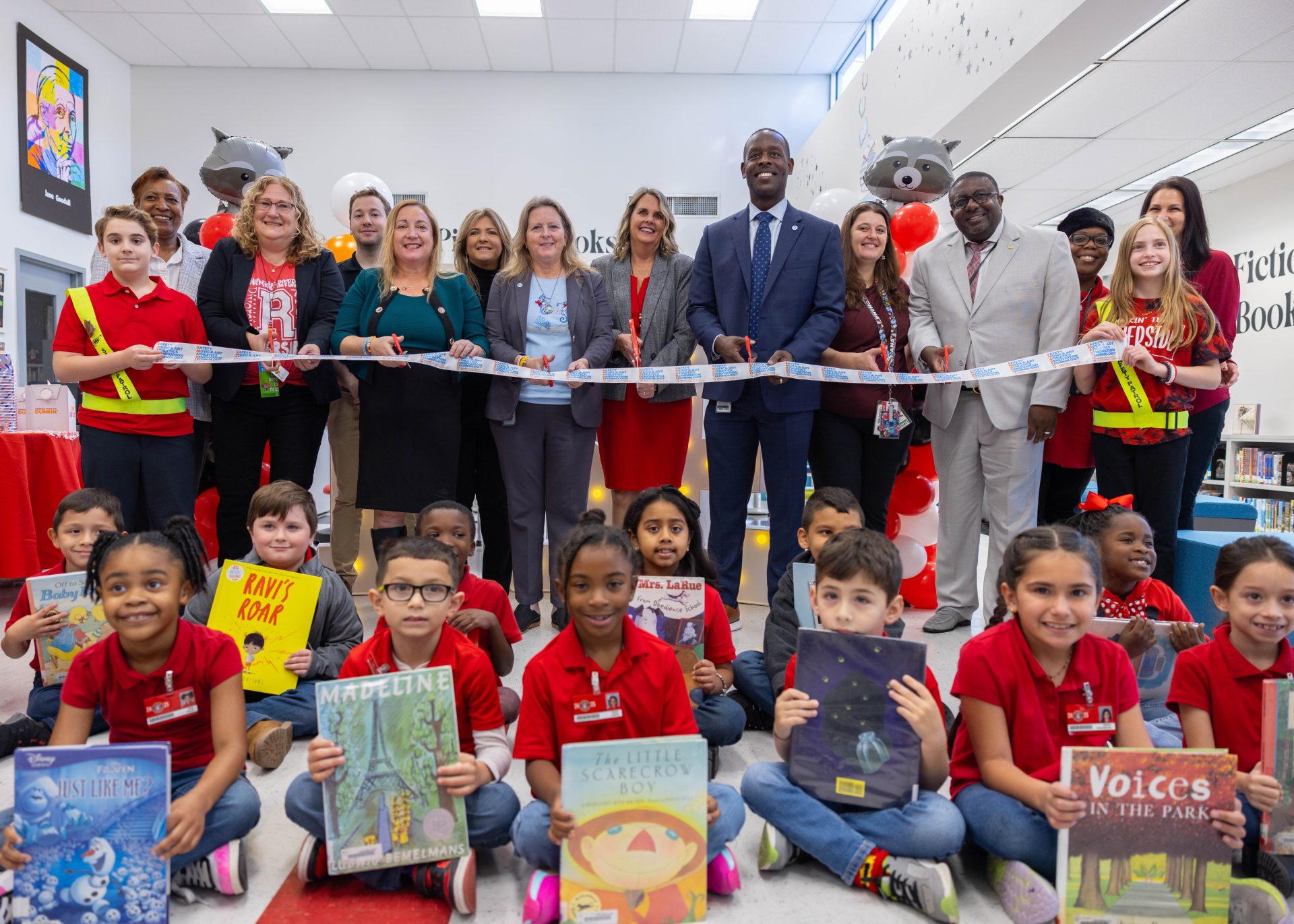Students sitting in front of teachers for a ribbon cutting
